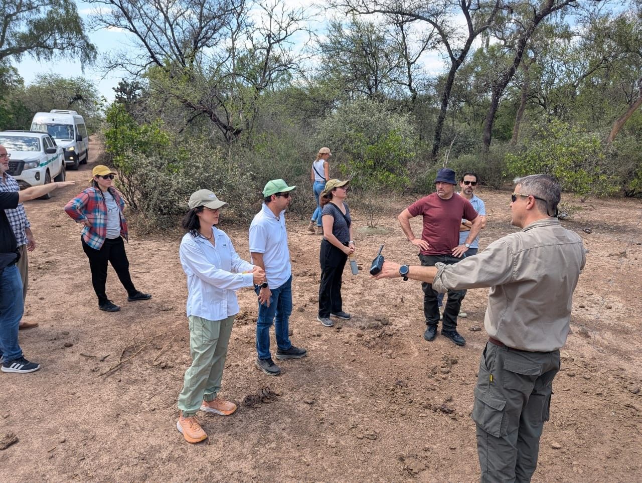 Un grupo escucha una explicación durante una recorrida de campo por el monte.